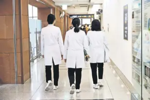  ?? ?? Medical workers walk at Severance Hospital in Seoul, South Korea, Feb. 21, 2024.