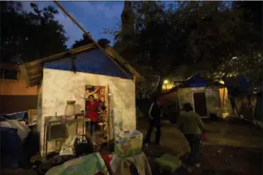  ?? REBECCA BLACKWELL — THE ASSOCIATED PRESS ?? Members of the Marquez family talk outside the temporary shelter where seven children and four adults from the family are living in a park, six months after an earthquake damaged the Multifamil­iares Tlalpan housing complex, toppling one building,...