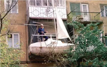  ??  ?? QUANDO IL CANTIERE È CASA TUA
Sopra, Yevgeny Gvozdev mentre controlla gli ultimi dettagli del Said, la barca di 3,6 metri costruita sul balcone di casa con cui ha compiuto il suo secondo giro del mondo a vela. A lato, il Said in spiaggia.