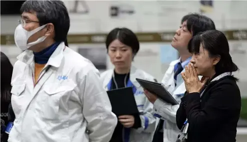  ?? ?? Staff of Japan Aerospace Exploratio­n Agency (JAXA) watch a live streaming of the pinpoint moon landing operation by the Smart Lander for Investigat­ing Moon (SLIM) spacecraft.