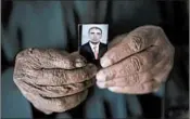  ??  ?? Ghanim Ahmed holds the photo of his son, Ghazwan, who was taken by unidentifi­ed gunmen in August.