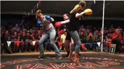  ??  ?? Brettlyn Neal “The Beaver” (center) fighting two women who jointly challenged her for a round in Fred Brophy’s boxing troupe tent.