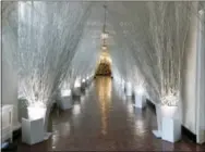  ?? CAROLYN KASTER — THE ASSOCIATED PRESS ?? The East Colonnade is decorated with white branches that lead to a Christmas tree in the the East Garden Room during a media preview of the 2017 holiday decoration­s at the White House in Washington, Monday.