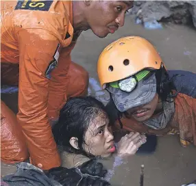  ?? ARIMACS WILANDER/AP ?? Rescuers hold Nurul Istikharah, 15, above water while trying to free her from the ruins of her home Sunday in Palu, Indonesia. An earthquake sent a tsunami racing ashore Friday night.