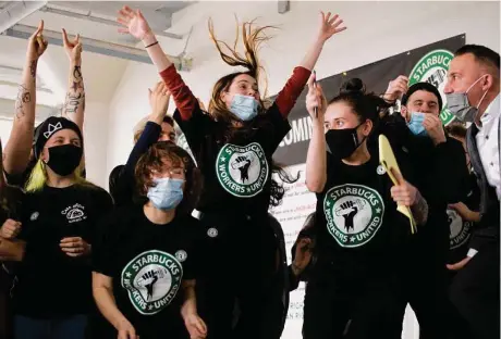  ?? Photos by Joshua Bessex / Associated Press ?? Starbucks employees react as votes are counted in their union election Dec. 9 in Buffalo, N.Y. The vote pointed to a new labor model for the 50-year-old coffee giant.