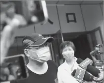  ??  ?? Left: A patient, surnamed He, the first in the capital to recover since the new cluster of infections was reported, is discharged from Beijing Ditan Hospital on June 29.