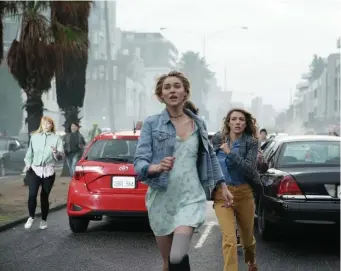  ?? ?? INTO THE PIT: Frightened residents of Los Angeles run as a massive sinkhole opens up in NBC’s ‘La Brea.’ Zyra Gorecki and Natalie Zea, from left, play family members who become separated.