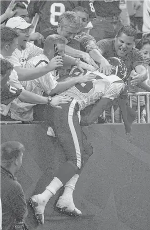  ?? Houston Chronicle file photo ?? Corey Bradford took the first celebrator­y leap into the Reliant Stadium stands as he celebrated his 65-yard touchdown that proved to be the game-winner on Sept. 8, 2002.