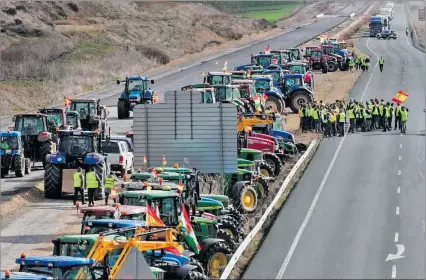  ?? EL PAÍS ?? La Rioja. Un grupo de agricultor­es corta el acceso al polígono Lentiscare­s, en la ciudad de Navarrete, ayer.