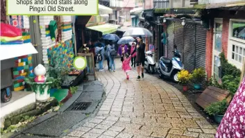  ??  ?? Shops and food stalls along Pingxi Old Street.