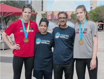  ?? BRADY MCDONALD/EDMONTON JOURNAL ?? Katherine, left, and Michelle Plouffe, from Canada’s senior women’s basketball team, proudly display their Pan Am Games gold medals while posing with Coun. Amarjeet Sohi and his daughter, Navseerat Sohi, during an Edmonton event to promote the...