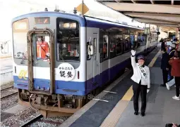  ?? The Yomiuri Shimbun ?? The first train of the day on the Noto Tetsudo railway departs for Nanao Station as a ceremonial station master for the day gives the go-ahead signal at Anamizu Station in Ishikawa Prefecture on April 6.