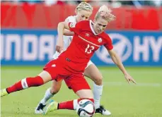  ?? Jeff McIntosh/THE CANADIAN PRESS ?? Canada’s Sophie Schmidt and New Zealand’s Betsy Hassett battle for the ball at Commonweal­th Stadium on Thursday.