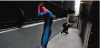  ??  ?? Two Spider-Man impersonat­ors, Rashad Rouse, front, and Juan Carlos Banegas, an immigrant from Honduras, change in the alley next to the TCL Chinese Theatre after working on Hollywood Boulevard in Los Angeles.