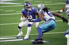  ?? Michael Ainsworth / Associated Press ?? Giants running back Devonta Freeman (31) looks for running room as Cowboys linebacker Jaylon Smith defends on Sunday.