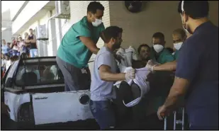  ?? ASSOCIATED PRESS ?? An injured person is lifted to a stretcher, Tuesday, outside the Getulio Vargas Hospital after a police raid on the Vila Cruzeiro favela in Rio de Janeiro, Brazil.