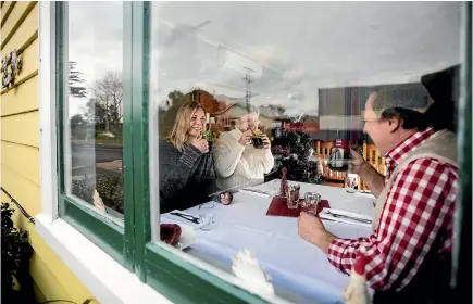  ?? PHOTO: ANDY JACKSON/STUFF ?? Belinda Lubkoll-Young, Renate Staudinger, and Heimo Staudinger sip on their mulled wine, which will be served at the Christkind­lesmarkt.