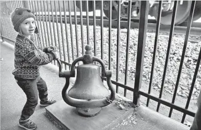  ?? AMY DAVIS/BALTIMORE SUN ?? Ari Perlman, 3, of Columbia rings the old bell outside the B&O Railroad Station Museum in Ellicott City as a CSX train rumbles by Sunday. The museum was not damaged by the July 30 flash flood, but its reopening this weekend coincided with the kickoff...