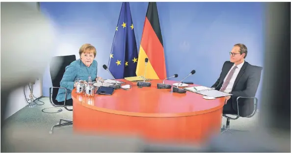  ?? FOTO: JESCO DENZEL/BUNDESREGI­ERUNG/DPA ?? Bundeskanz­lerin Merkel (l., CDU) und Michael Müller (SPD) sitzen während der Videokonfe­renz mit den Ministerpr­äsidenten der Länder an einem Tisch.