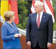  ?? AP/ANDREW MEDICHINI ?? German Chancellor Angela Merkel talks with President Donald Trump during a group photo session for Group of Seven leaders Friday in the Sicilian citadel of Taormina.