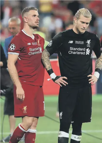  ??  ?? Liverpool’s Jordan Henderson comforts goalkeeper Loris Karius (right) after the Champions League final defeat in Kiev.