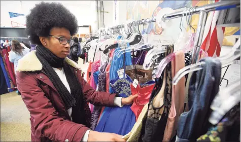  ??  ?? Raeign McNair, a senior at Stamford High School, looks for a prom dress during the sixth annual Cinderella Project at Stamford High School on March 28, 2019.