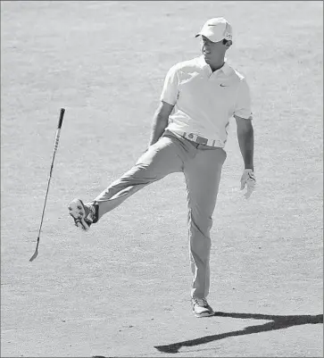  ?? David Cannon Getty Images ?? RORY McILROY GIVES his club a kick after his second shot on the seventh hole. He trails by nine shots.