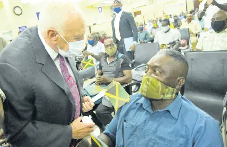  ?? BROWN/PHOTOGRAPH­ER RUDOLPH ?? United States Ambassador Donald Tapia (left) talks with 39-year farm-work veteran Ronald Campbell at a send-off ceremony at the Ministry of Labour and Social Security Overseas Employment Services Centre on East Street, Kingston, on Thursday.