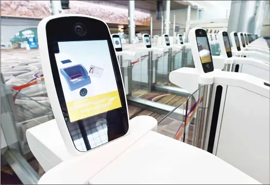  ??  ?? This photograph taken on July 25 shows the passport scanner gantry during a media tour of the newly built Changi airport terminal 4 in Singapore. New technology is rapidly being rolled out, transformi­ng the exhausting experience of getting stuck in...