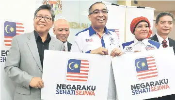  ??  ?? Salleh (centre) and Sharifah Zarah (second right) show the theme of this year’s National Day and Malaysia Day 2017 celebratio­n ‘Negaraku Sehati Sejiwa’. — Bernama photo