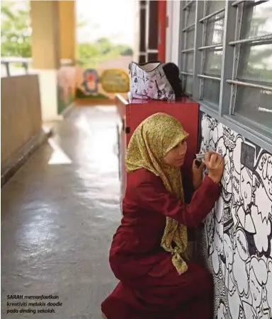  ??  ?? SARAH memanfaatk­an kreativiti melukis doodle pada dinding sekolah.