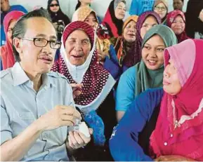  ?? PIC BY LANO LAN ?? Barisan Nasional candidate for the Karanaan state seat, Datuk Seri Masidi Manjun, enjoying ‘moginggat’ in Ranau, Sabah, yesterday.