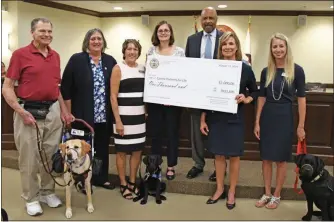  ?? SUBMITTED PHOTO -BECKY BRAIN ?? Everybody, including even the dogs, are smiling about a check presentati­on to Canine Partners for Life.