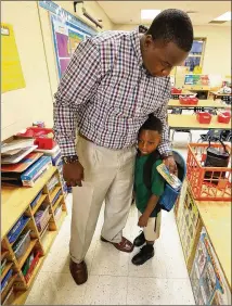  ?? CURTIS COMPTON / CCOMPTON@AJC.COM ?? Jason Heflin hugs his 5-year-old son Jason Heflin II goodbye Monday after walking him to Jennifer Byron’s kindergart­en class on the first day of school at Bouie Elementary School in Lithonia. For most students, the start of the new school year went...