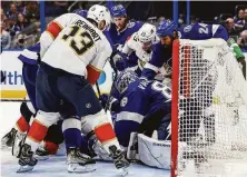  ?? Mike Carlson / Getty Images ?? Andrei Vasilevski­y of the Lightning (bottom) makes a save in a crowd against the Panthers during the third period.