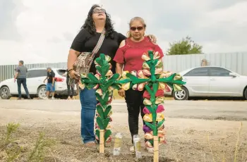  ?? JAY JANNER/AUSTIN AMERICAN-STATESMAN ?? Debra Ponce, left, and Angelita Olvera pray Tuesday in San Antonio near where officials said dozens of people were found dead after a tractor-trailer containing migrants was discovered a day earlier.