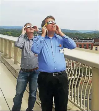  ?? CONTRIBUTE­D PHOTO ?? Community Health Center staff Nick Ciaburri and Conrad Kunz donned special solar eclipse viewing glasses to witness the phenomenon Monday afternoon on the rooftop at 675 Main St., Middletown, where several dozen others also gathered.
