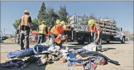  ??  ?? CREWS collect trash left by homeless people in the camp. Monday’s cleanup was prompted by complaints from nearby residents about filth and crime.