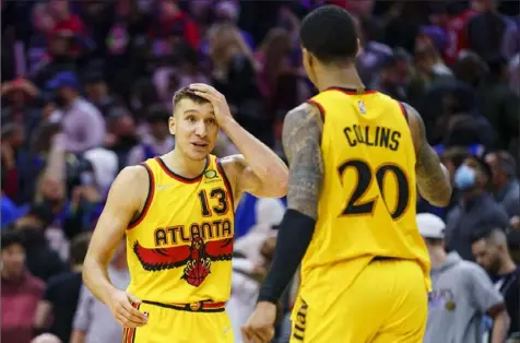  ?? Associated Press ?? Atlanta Hawks wing Bogdan Bogdanovic, left, had a fourth quarter so good even he couldn't believe it as the Hawks beat Philadelph­ia, 98-96.