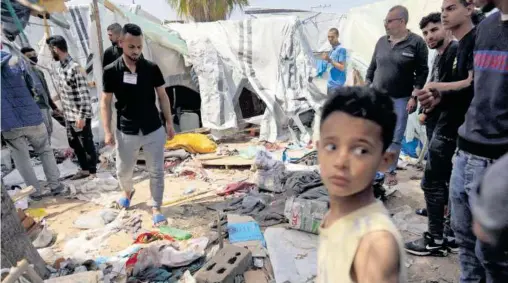  ?? AFP ?? Palestinos observan los daños causados al hospital Al-aqsa, que fue destruido en un asedio de fuerzas israelíes