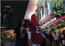  ?? Marie D. De Jesús / Houston Chronicle ?? Darwin Carriel and Ashley Haddock of Clear Lake check out the downtown area spruced up for the Super Bowl and the tens of thousands of visitors it attracts.