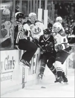  ?? Herald photo by Tijana Martin ?? Ty Perfontain­e, of the Lethbridge Hurricanes, checks Zak Smith of the Red Deer Rebels into the player's bench during a game at the Enmax Centre on Friday night.