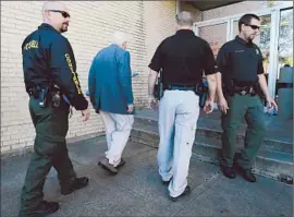  ?? Tony Gutierrez
Associated Press ?? A SECURITY ESCORT sees an employee into the Kaufman County Courthouse. Links were being sought between the shootings and a white supremacis­t gang.