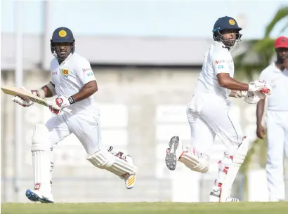  ?? AFP ?? Kusal Perera (left) and Dilruwan Perera helped Sri Lanka coast to a four-wicket win over the West Indies. —