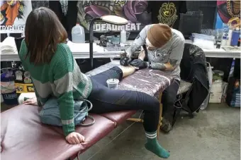  ?? STAFF PHOTO ?? Nick Keiser, right, tattoos Sandy Baker during Literary Ink, a Harry Potter-inspired tattoo convention at the Chattanoog­a Convention Center in 2019.