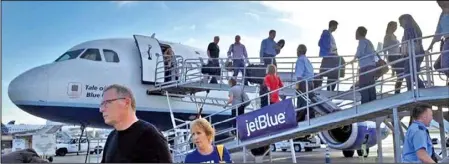  ??  ?? 捷藍航空公司（JetBlue Airways）的一架飛機在長堤機場­降落，旅客陸續下機。長堤機場今年上半年旅­客激增50%。 （美聯社）編譯組 綜合 日報導