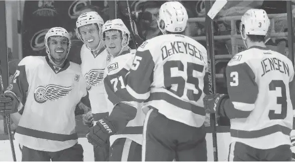  ?? GERRY BROOME / THE ASSOCIATED PRESS ?? Members of the Detroit Red Wings congratula­te Anthony Mantha, second from left, after he scored in Monday’s game against Carolina. After some rough emotional times for the storied team lately, the pending move to a new arena has put a spring back into the steps of players, coaches, fans and management.