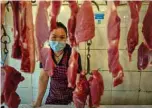  ??  ?? A vendor wearing a face mask as she works at her stall in a market in Wuhan in China’s central Hubei province.