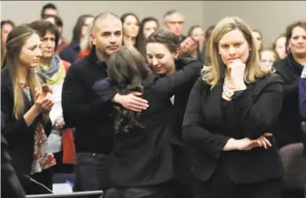  ?? Carlos Osorio / Associated Press ?? Former gymnast Rachael Denholland­er (center) is hugged after giving her victim impact statement during Larry Nassar’s sentencing hearing in January in Lansing, Mich.