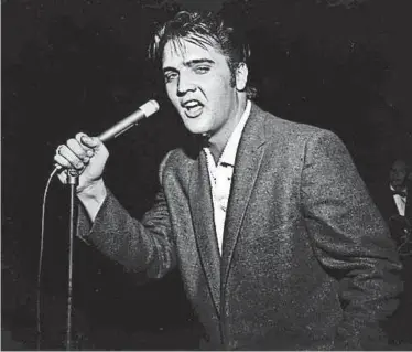  ?? THE COMMERCIAL APPEAL FILES ?? More than 7,000 people jammed Ellis Auditorium on the night of May 15, 1956, to stomp, shudder, shriek and sigh as a young Elvis Presley writhed his way through a rock and roll repertoire. Presley was the blockbuste­r of Bob Neal's Cotton Picking...